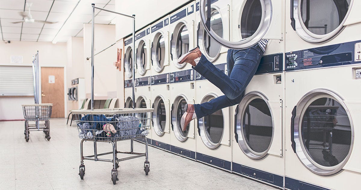 Woman washing clothes at the laundromat.